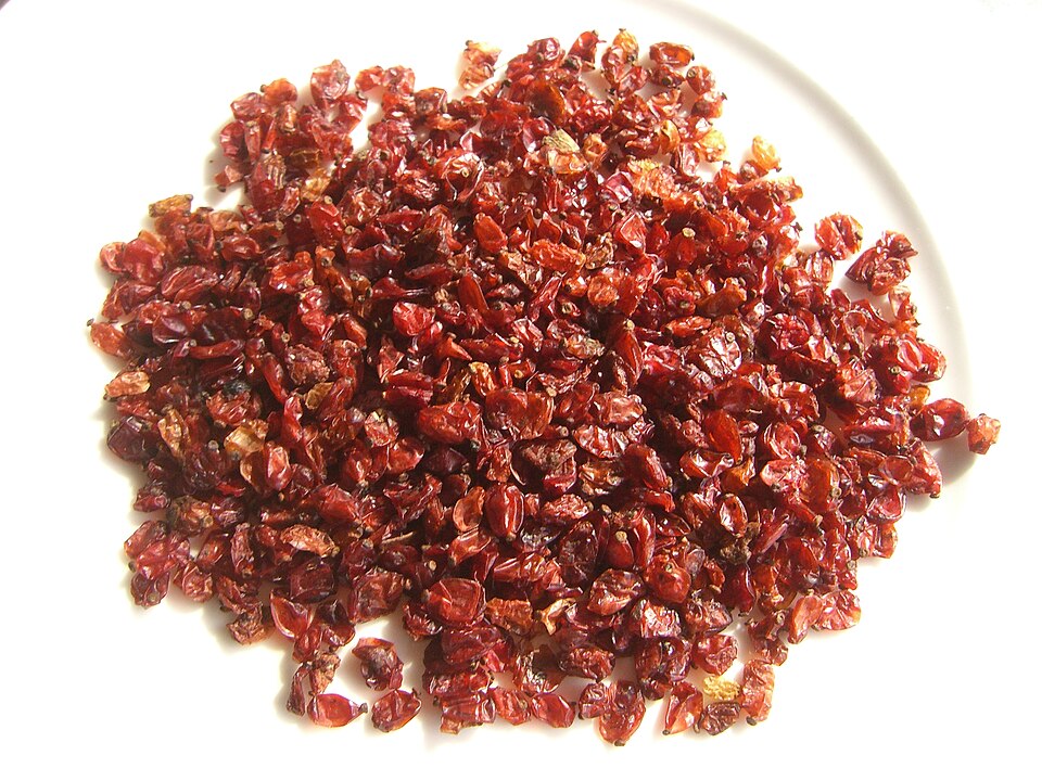 Red dried barberries on a white plate